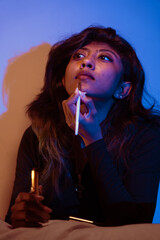 Obraz premium A woman is applying makeup in a dimly lit room