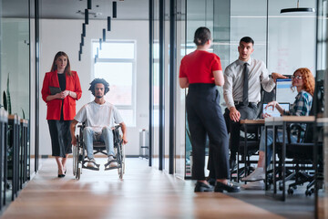 A business leader with her colleague, an African-American businessman who is a disabled person,...