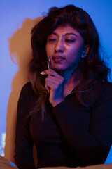 Obraz premium A woman is sitting and smoking a cigarette