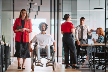Fototapeta premium A business leader with her colleague, an African-American businessman who is a disabled person, pass by their colleagues who work in modern offices