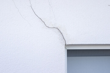 Detail of a crack in the facade cladding near the window lintel area