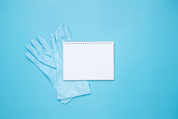 Various accessories cleaning products. Mock up white notebook and rubber glove. Top view, flat lay,...