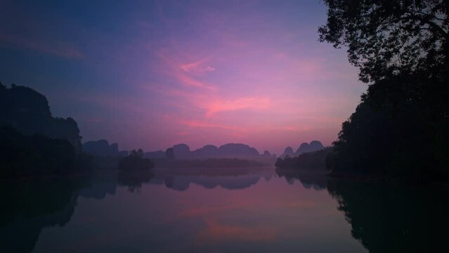 Time lapse Pastel Pink Sunrise over the swamp. Peaceful Seascape over lake Nong Thale Krabi. with Clouds and forest Reflected on Sea Water. Panoramic Horizon Coastal Landscape. Landscape Nature