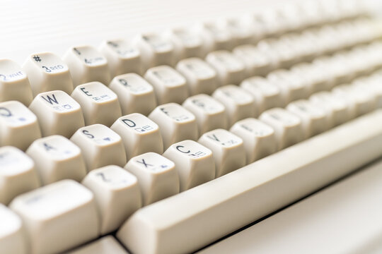 Close-up of vintage Commodore 64 keyboard with cream-colored keys and letters. Daylight illuminating the retro computer.