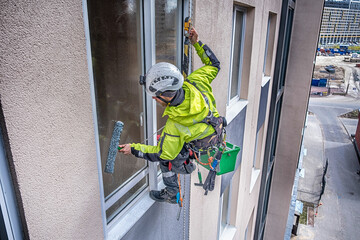 Rope access specialist washes glass