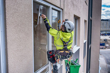 Rope access specialist washes glass