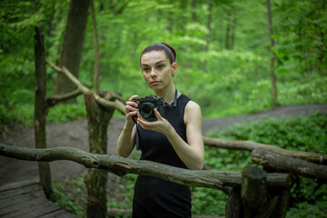 Girl with a camera exploring the lush green forest, capturing its beauty through the lens of her camera.