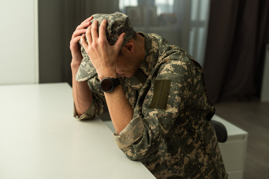 A distraught soldier covering his face, possibly suffering from shell shock or Post Traumatic Stress Disorder