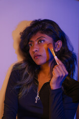 Obraz premium A woman is applying makeup with a brush