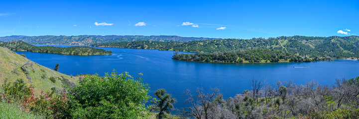 panoramic landscape with lake and mountains blue sky with some white cloud  