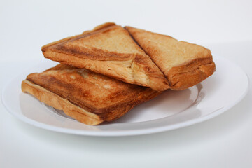 Some toasts or toasted breads, on white plate, isolated on white background