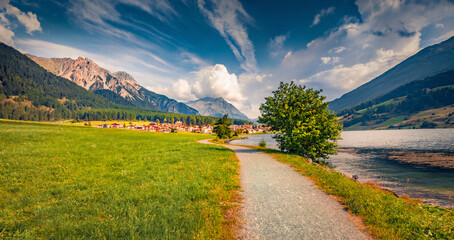 Tourist path to St. Valentin village. Impressive morning view of Muta lake (Haidersee), South Tyrol, Italy, Europe. Traveling concept background.