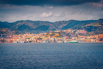 Dramatic morning cityscape of Messina port with old colorful buildings, Sicily, Italy, Europe. Wonderful summer seascape of Mediterranean sea. Traveling concept background.