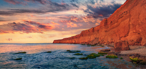 Sunset in Crimea peninsula. Fantastic summer view of Lukull red cliff on the sea shore. Majestic...