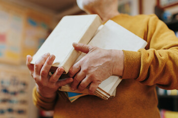 Detailed Close-up of Old Man's Hands Positioned Near a Book
