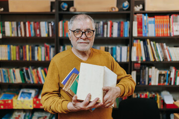 Portrait of a Senior Man Holding Books in a Bookstore