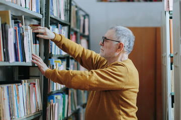 Literary Decision Portrait of a Senior Man Choosing a Book from the Shelf