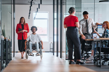 A business leader with her colleague, an African-American businessman who is a disabled person,...