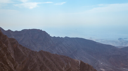 Naklejka premium Jebel jais mountain, Majestic Rocky Mountains Under Clear Blue Sky During a Sunny Day