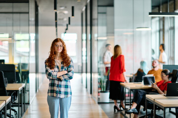A portrait of a young businesswoman with modern orange hair captures her poised presence in a...