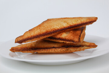 Some toasts or toasted breads, on white plate, isolated on white background