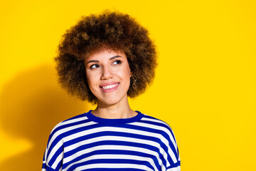 Portrait of pretty young woman look empty space wear striped shirt isolated on yellow color...