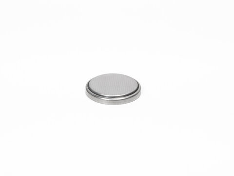 CR2032 button cell battery close up on a white background.