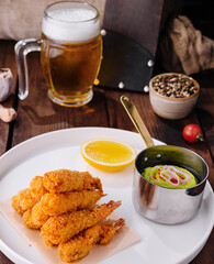 Fried shrimp platter with dipping sauce and beer