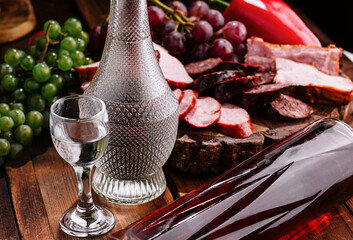 Luxurious vodka and charcuterie spread on wooden table