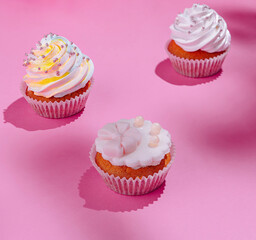 Festive cupcakes on pink background