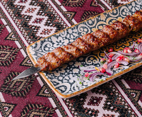 Traditional grilled kebab on ornate plate