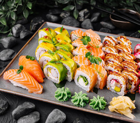 Assorted sushi and rolls platter on stone background