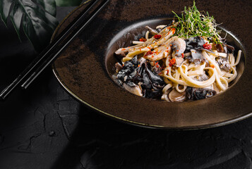 Exquisite asian noodle dish on elegant dark plate