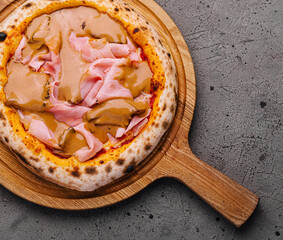 Gourmet italian pizza with ham on wooden board