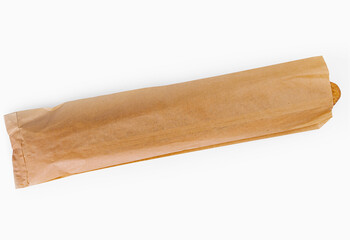 Fresh baguette in brown paper bag on white background