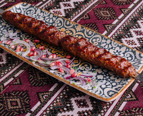 Traditional grilled kebab on ornate plate