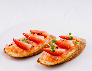 Gourmet smoked salmon toasts on white plate