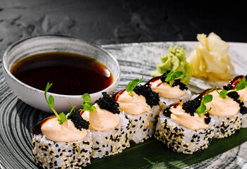 Gourmet sushi roll platter with caviar and soy sauce