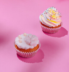 Festive cupcakes on pink background