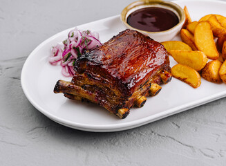 Succulent bbq pork ribs with wedges and sauce