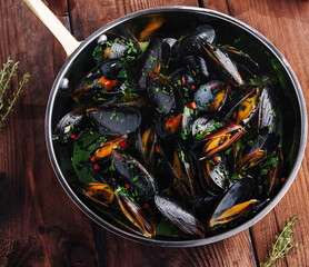 Appetizing mussels in herb broth top view