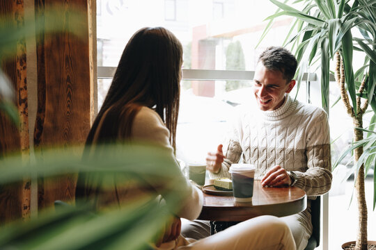 Man and Woman Sitting at Table Talking