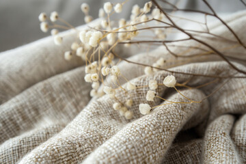 Obraz premium Closeup of dried flowers on a blanket with a wood twig pattern. Generative AI