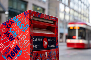 Naklejka premium Canada Post box in Downtown Toronto. Canada Post Corporation is a Crown corporation that functions as the primary postal operator in Canada. Toronto, Canada - April 29, 2024.