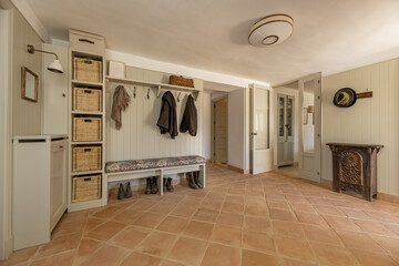 Large living room in a country house with rustic style terracotta floors with a bench to change...