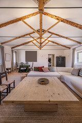 Living room of a country house with wooden and metal trusses on the roof, vintage-style wooden...
