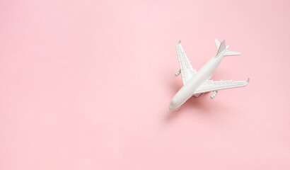 Airplane with passport and tickets on the bright sunny pink background. Vacation travel...