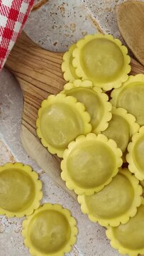 tas de raviolis crus, en gros plan, sur une planche &agrave; d&eacute;couper	