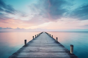 Fototapeta premium A serene coastal scene with a single wooden pier extending into a calm ocean at dawn, space for text