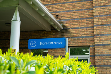 Store entrance signpost with the building in the background